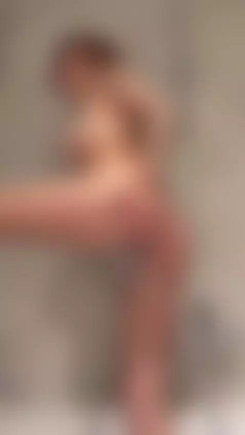 Raised leg in the shower, water jet pressed tight against he... by julcypeach