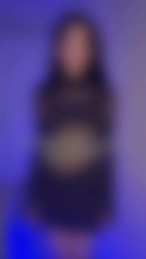 She turns slow in the blue light, curves on full display by sofits