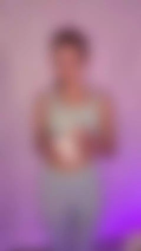 Soft curves gleam under purple light as she wipes her skin s... by sofits